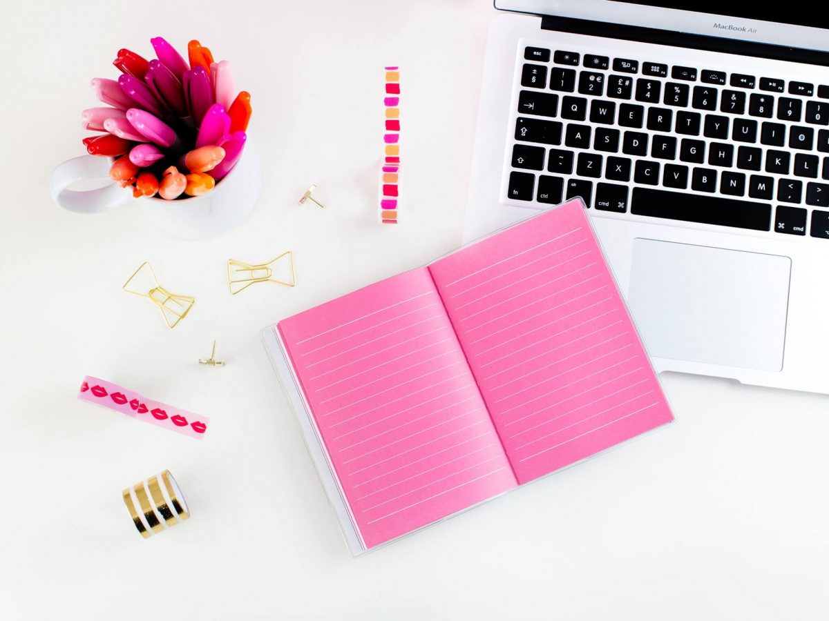 pink notebook on desk - content savvy