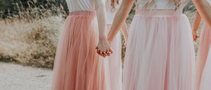 women holding hands in pink skirts