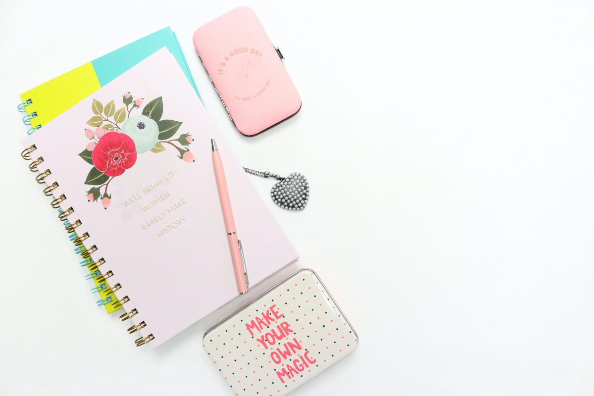 pink notepads and pen - writing a mission statement in easy steps