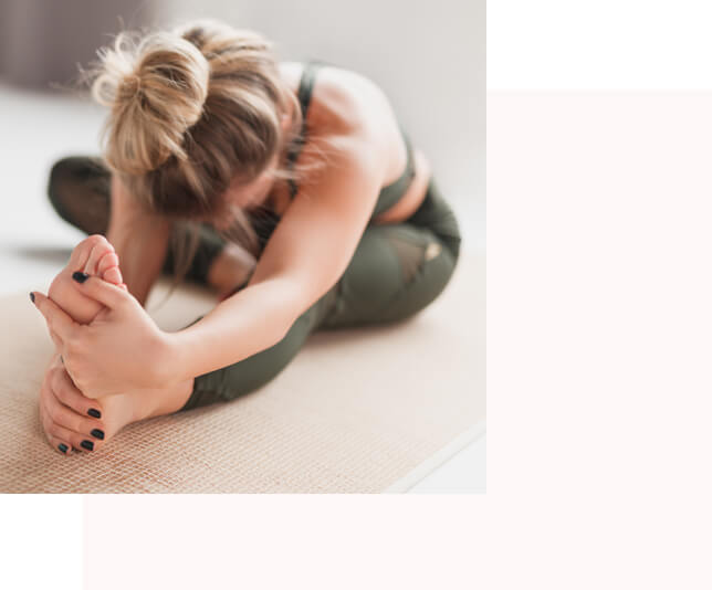 A woman stretching her leg out in a yoga wellness pose to connect back with her toes and foot
